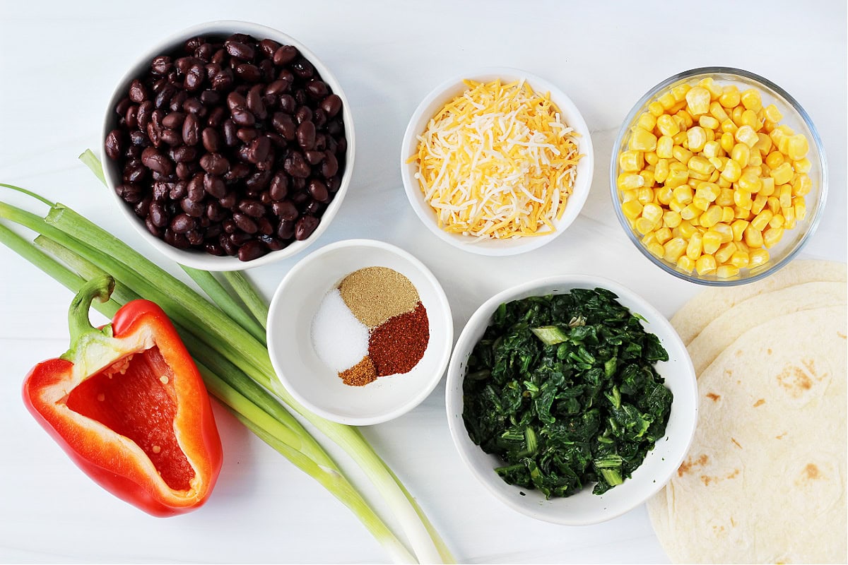 Overhead photo of ingredients for southwest egg rolls like black beans and fresh veggies.