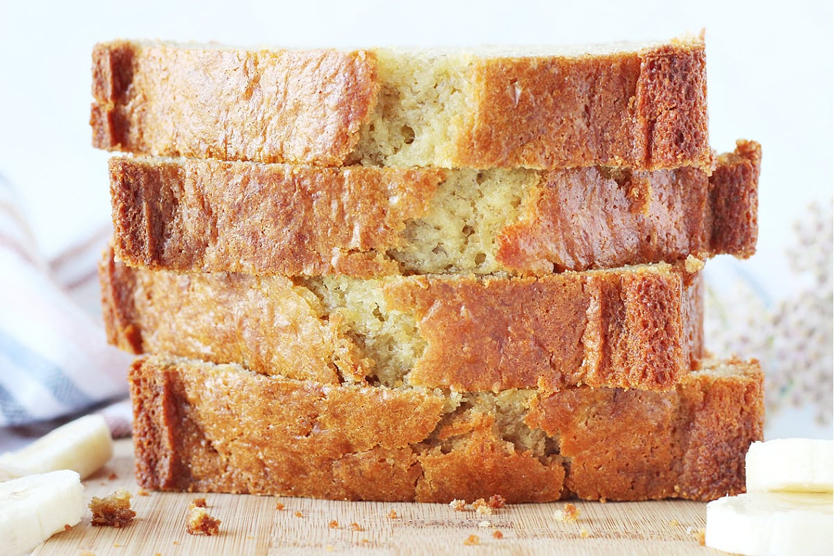 Up close photo of a stack of four thick slices of banana bread.