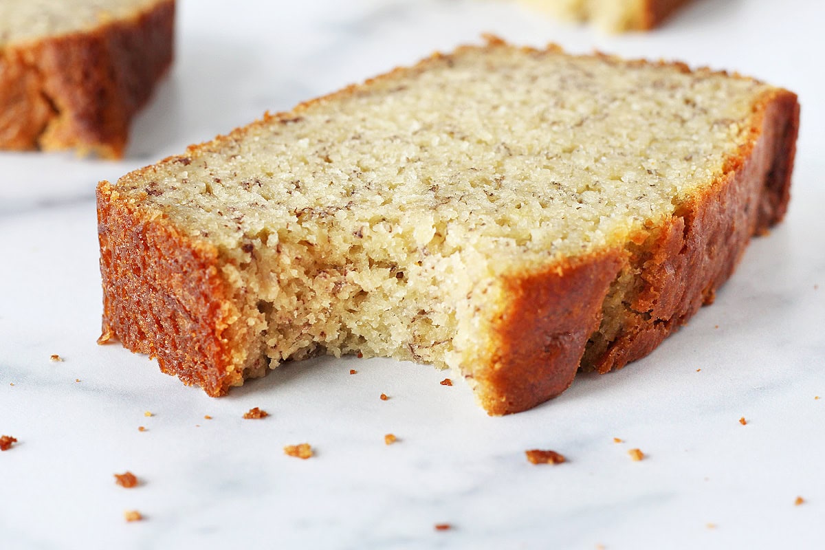 Up close photo of a slice of banana bread with a bite taken out.