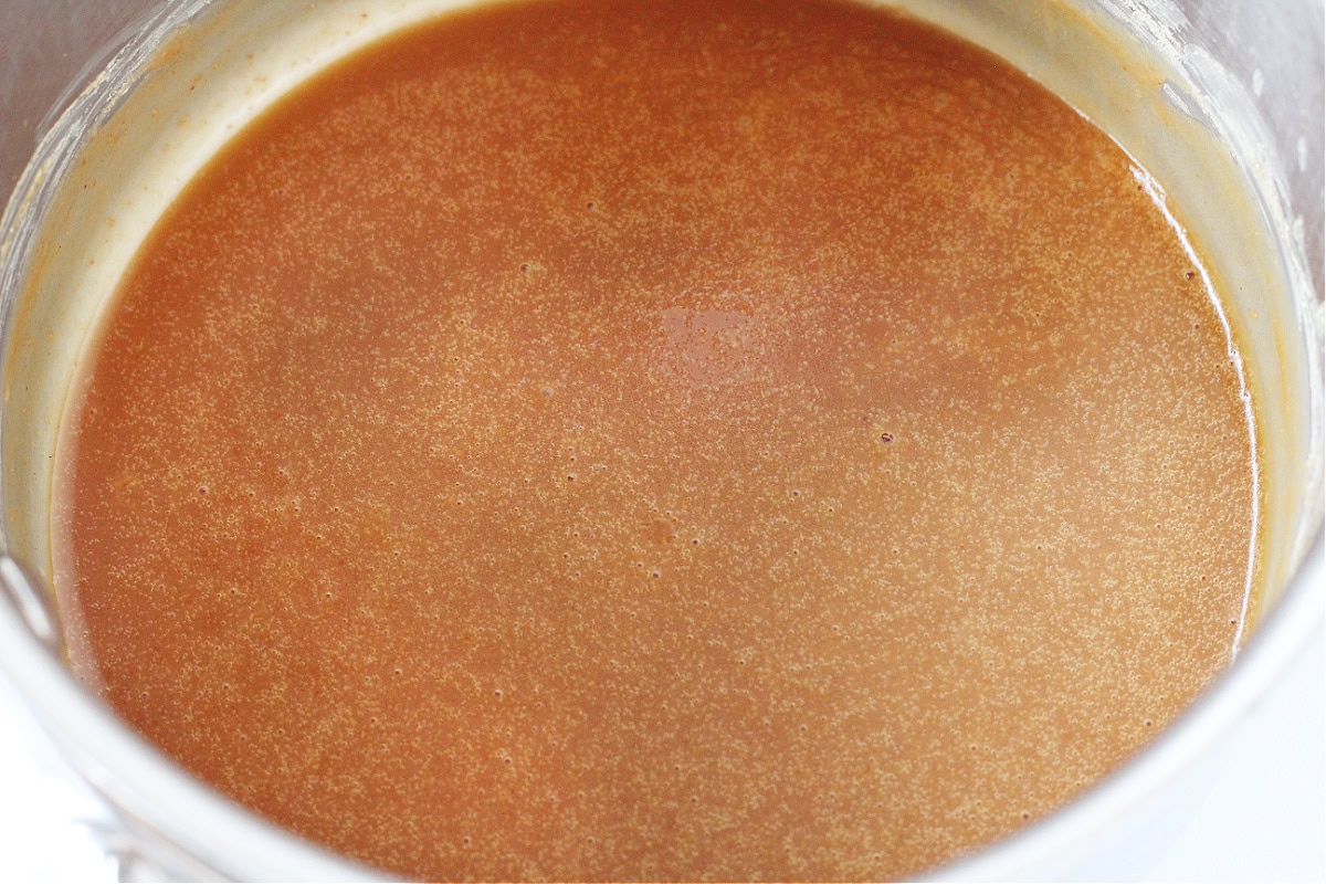 A sweet peanut butter caramel sauce in a stainless steel stovetop pan.