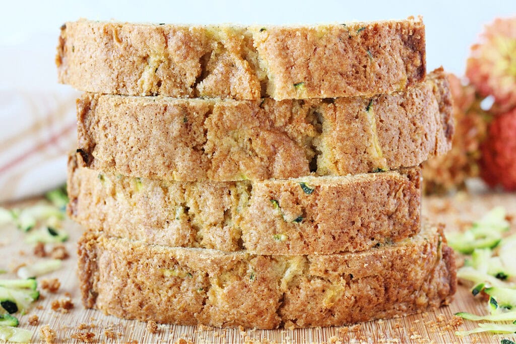 Four slices of thick cut zucchini bread stacked on top of each other.