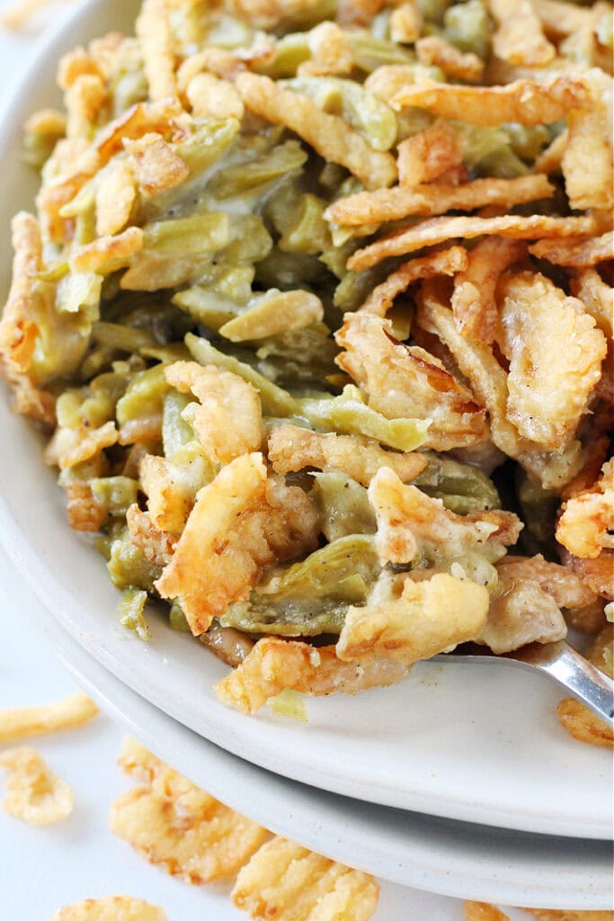 Easy green bean casserole on a fork on a white plate.