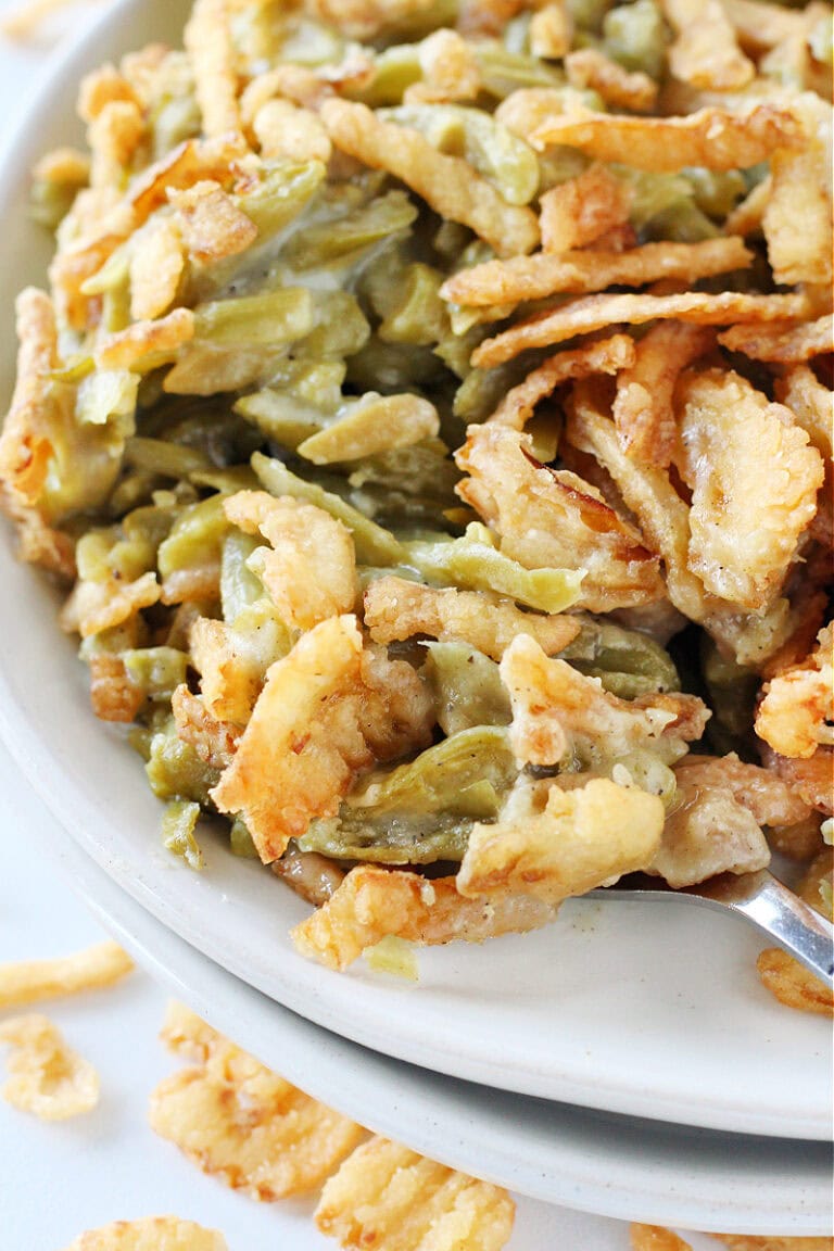 Easy green bean casserole on a fork on a white plate.