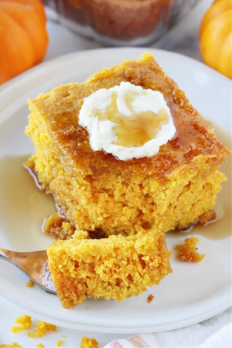 Pumpkin cornbread on a fork with maple syrup.