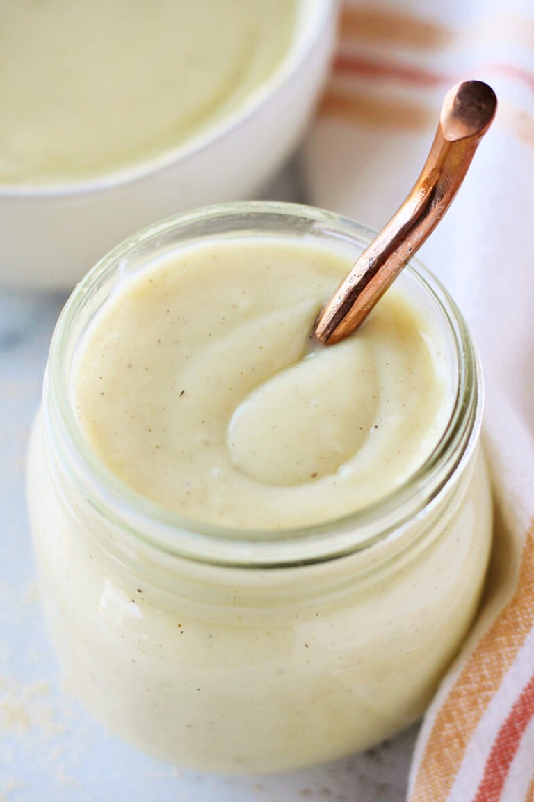 Homemade cream of chicken soup in a glass jar with a copper spoon.