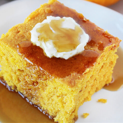 Up close slice of healthy pumpkin cornbread topped with butter and maple syrup.