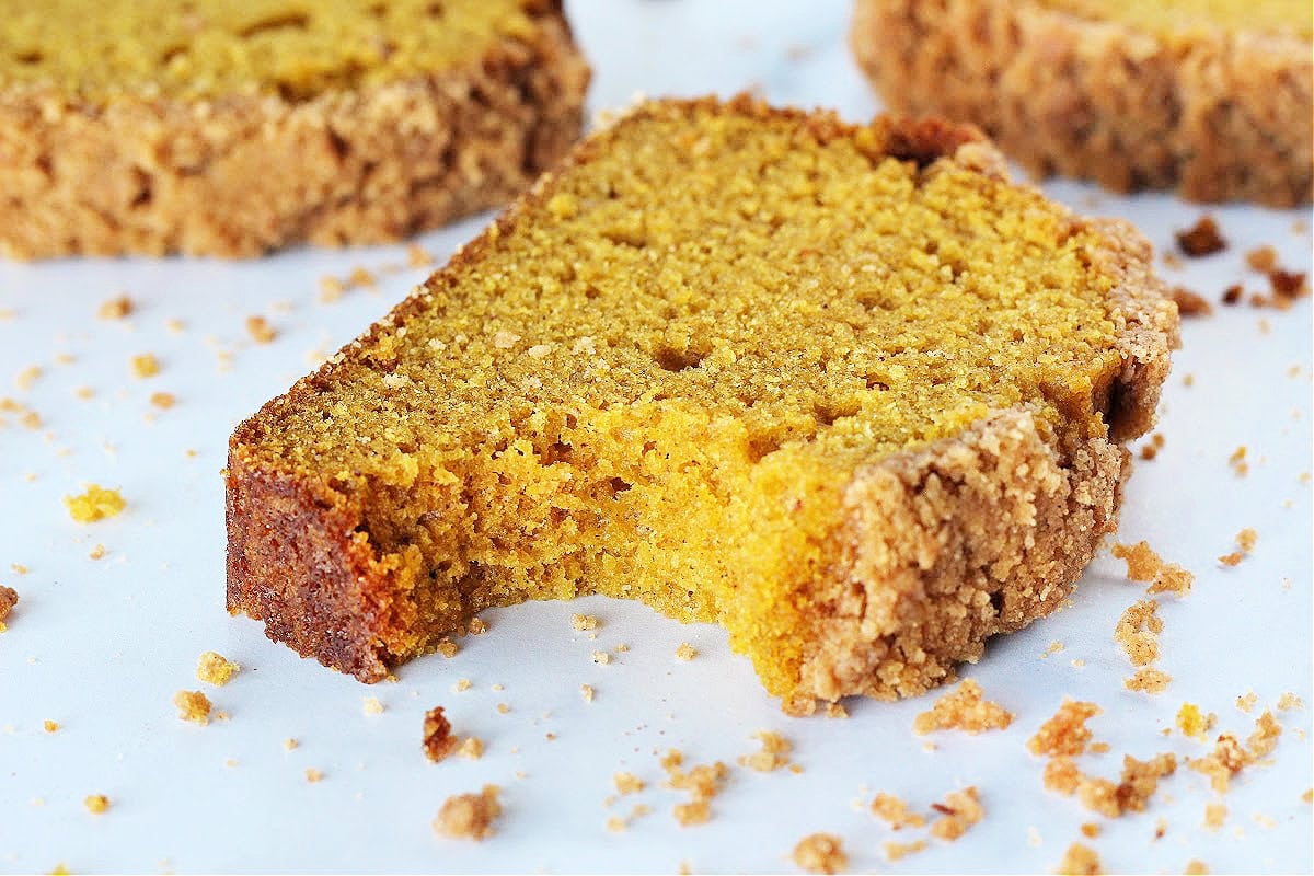 A slice of pumpkin bread with a bite taken out.