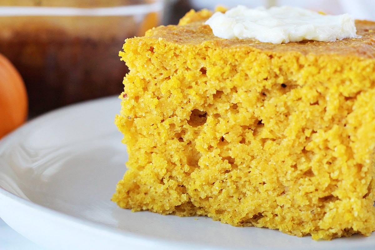 Slice of pumpkin cornbread topped with butter.