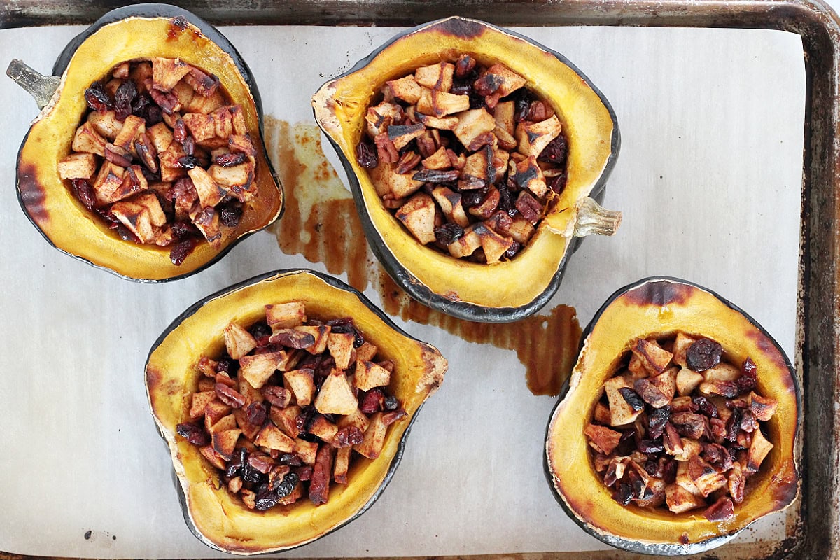 Overhead photo of four baked stuffed squashes on a baking sheet.