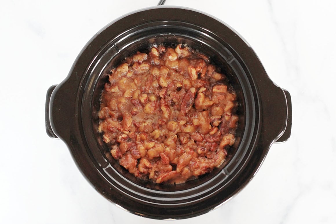 Cooked slow cooker sweet potato casserole with caramelized pecan topping.