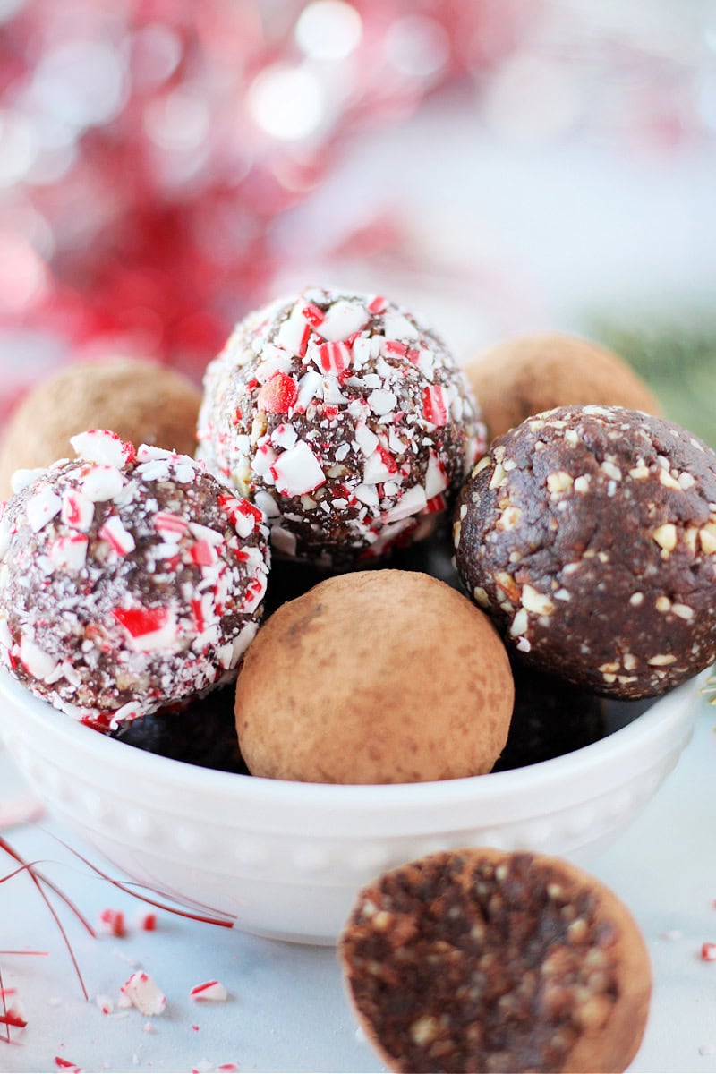 No bake chocolate mint balls some coated in crushed candy canes and cocoa powder.