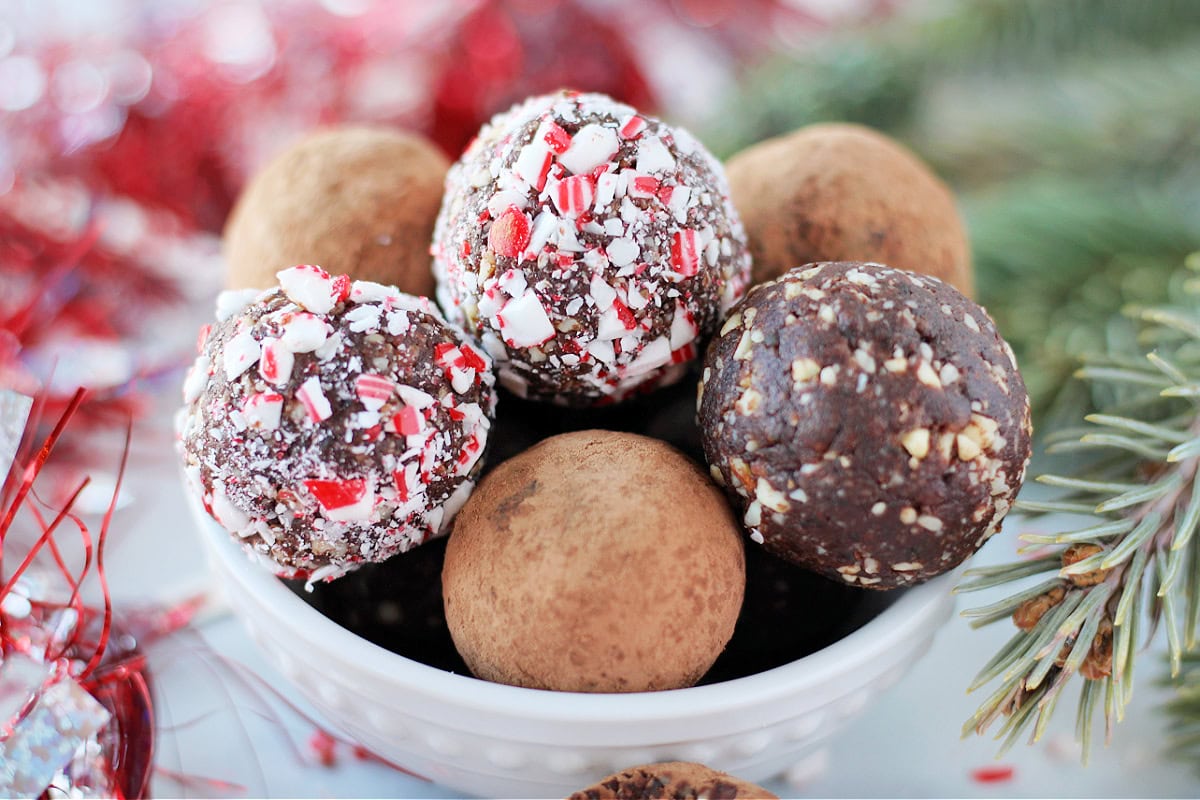 Up close photo of chocolate balls stacked in a white bowl.