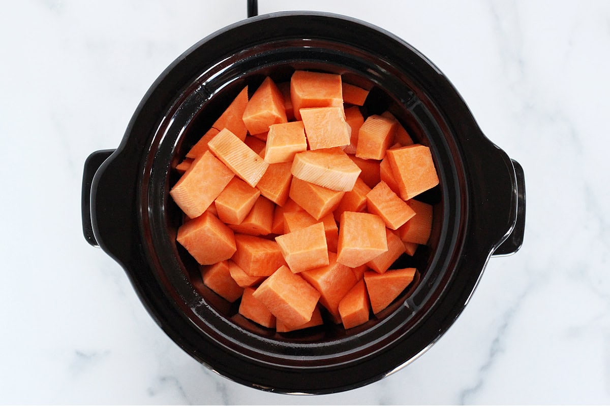 Overhead photo of a small crockpot filled with diced sweet potatoes.