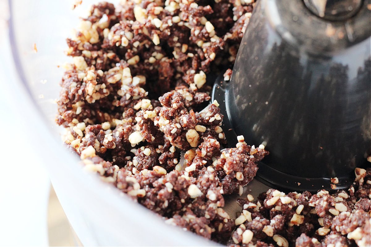 The batter of almonds, cocoa powder and dates in a food processor.