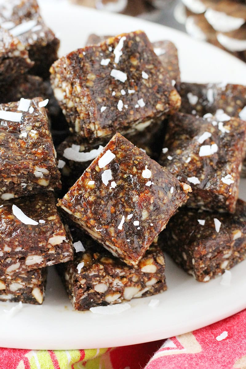 Up close photo of square gingerbread bites on a plate topped with unsweetened coconut shreds.