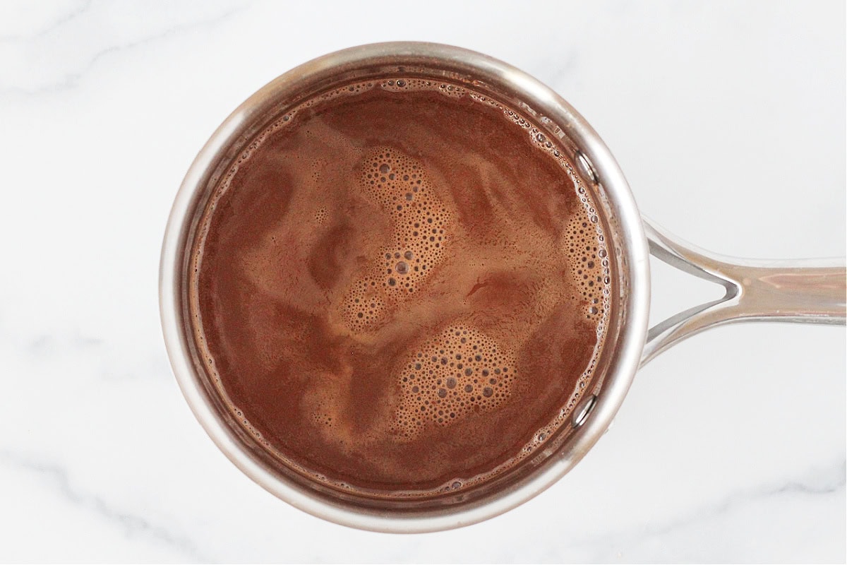 Overhead photo of a small soup pot with homemade hot cocoa.