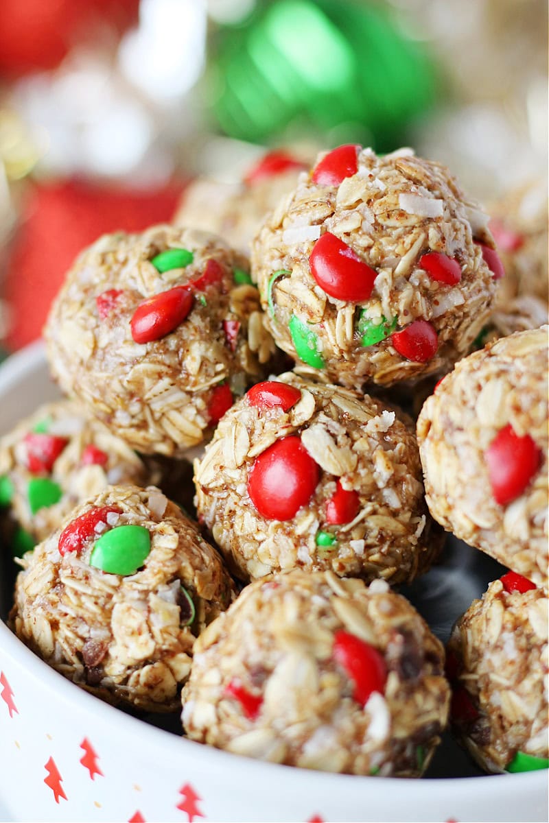 No bake Christmas energy bites stacked in a white holiday bowl.