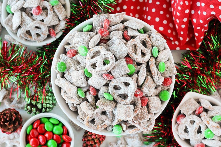 Overhead photo of Reindeer Chow in bowls surrounded by Christmas garland and decor.