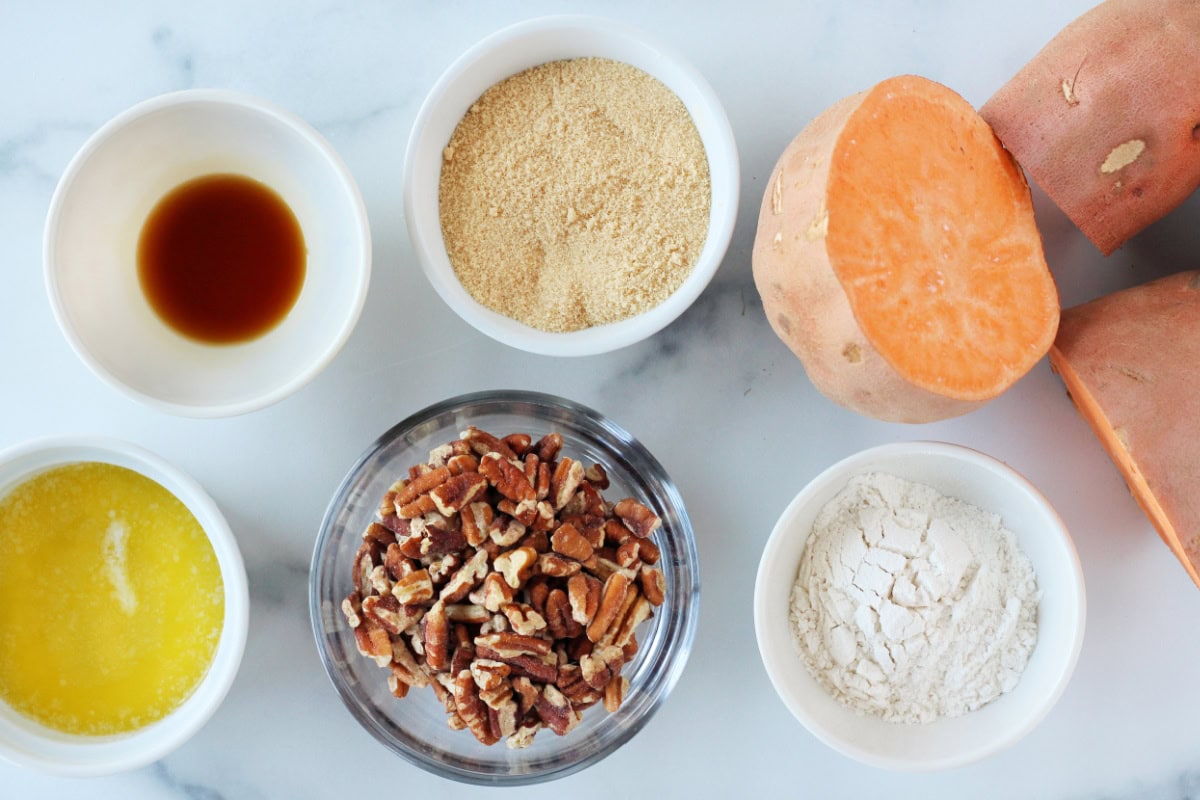 Ingredients for healthy sweet potato casserole in bowls on a white countertop.