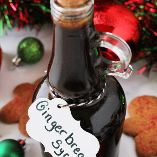 Tall glass jar filled with gingerbread coffee syrup with a labeled white tag.