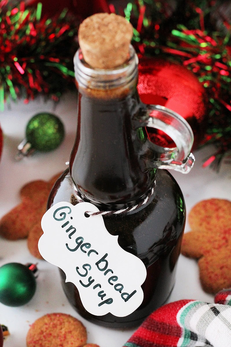 Tall glass jar filled with gingerbread coffee syrup with a labeled white tag.