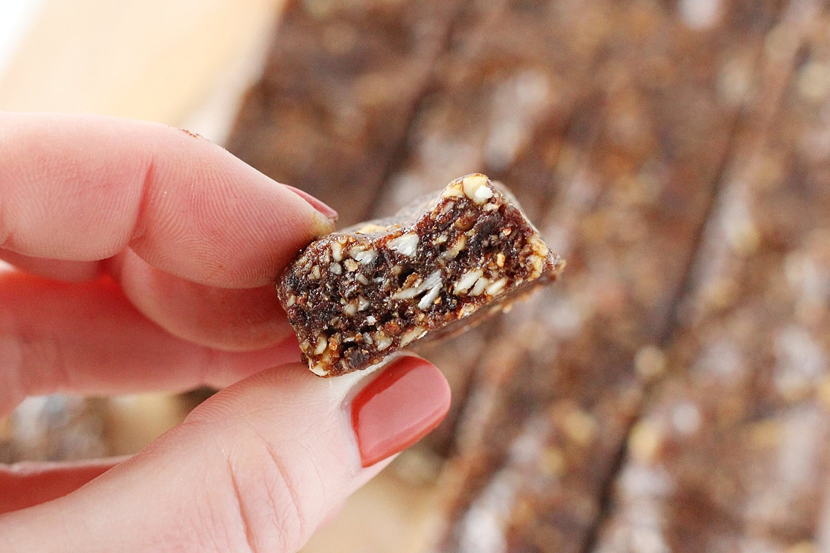 A woman's fingers holding a raw gingerbread bite.