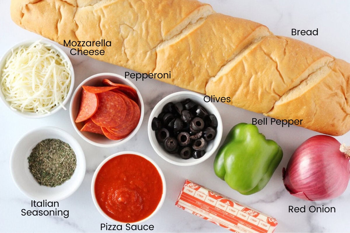 Labeled ingredients for garlic bread pizza on a white marble countertop.