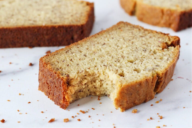 A bite taken out of a thick slice of gluten free banana bread.