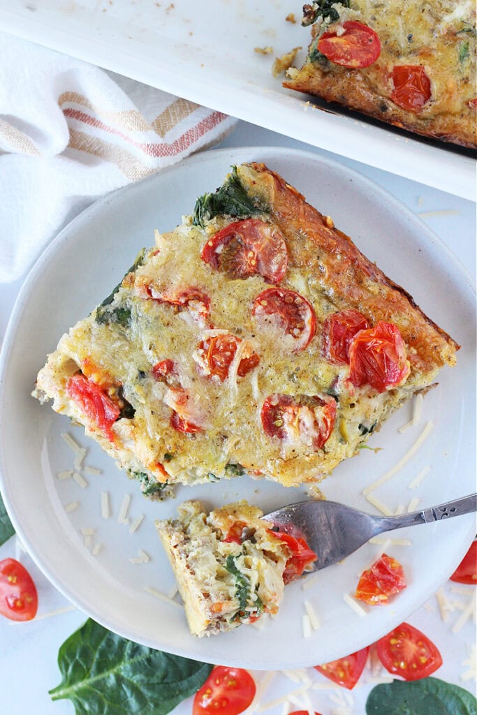 Overhead photo of a slice of egg casserole and a fork on a plate.