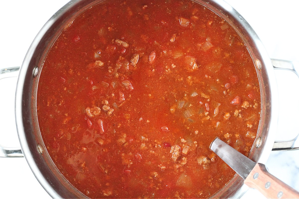 A one pot chili with a ladle in it.