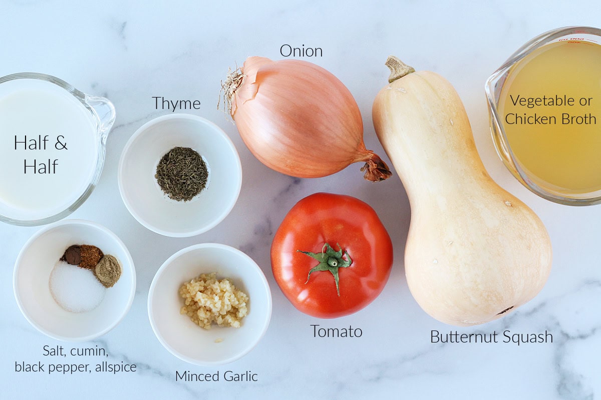 Labeled ingredients for easy roasted butternut squash soup on a white marble countertop.
