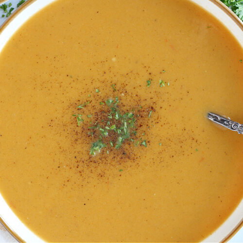 Overhead photo of a bowl of roasted butternut squash soup with a vintage spoon.