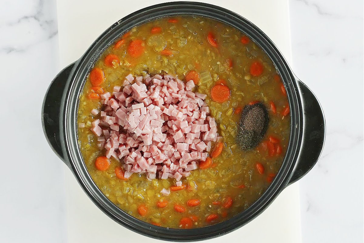 Overhead photo of split pea soup topped with diced ham and seasonings.