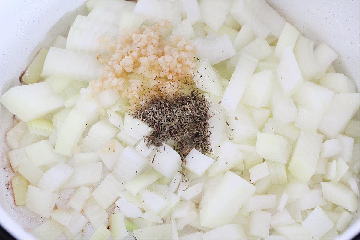 Diced onion, minced garlic and dried thyme in a white soup pot.