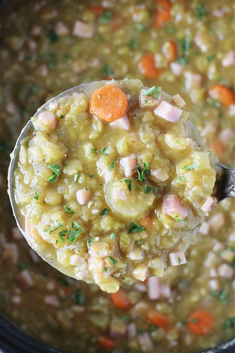 Overhead photo of split pea soup in a ladle over the soup pot.