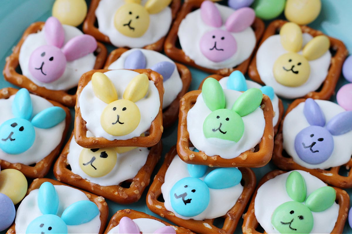 Pastel colored M&M bunny pretzels stacked on a plate.