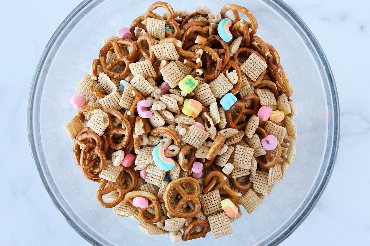 A bowl of Chex cereal, pretzels, and Lucky Charms marshmallows.