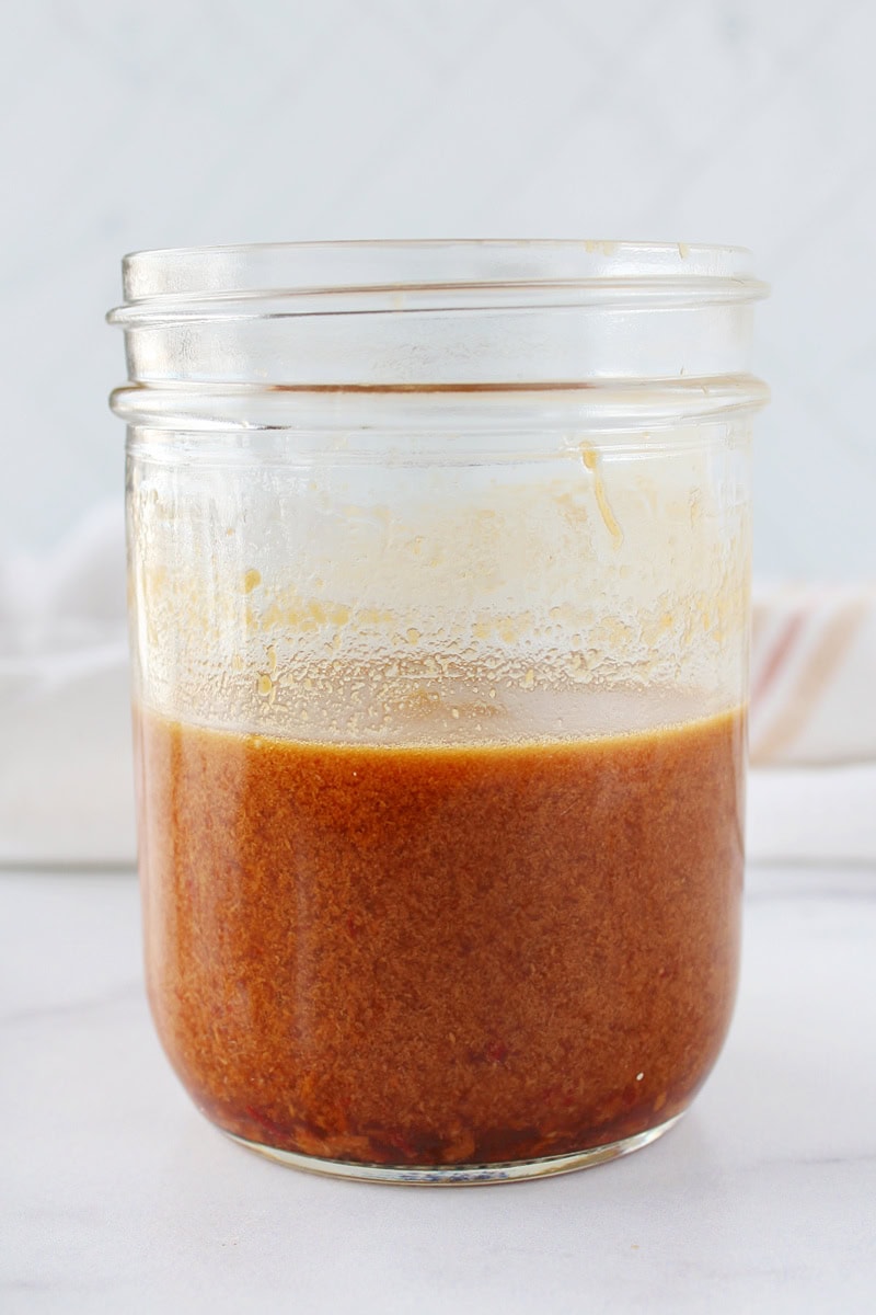 A creamy peanut dressing in a mason jar.