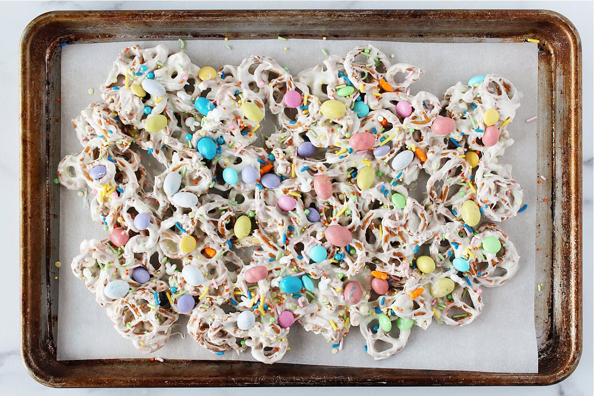 Easter candies scattered on twisty pretzels covered in melted white chocolate chips.