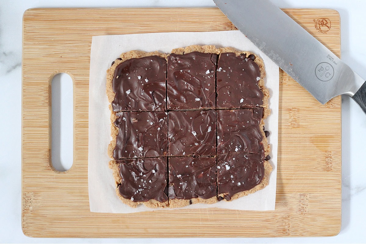 Cookie dough bark topped with flaked sea salt cut into nine squares.