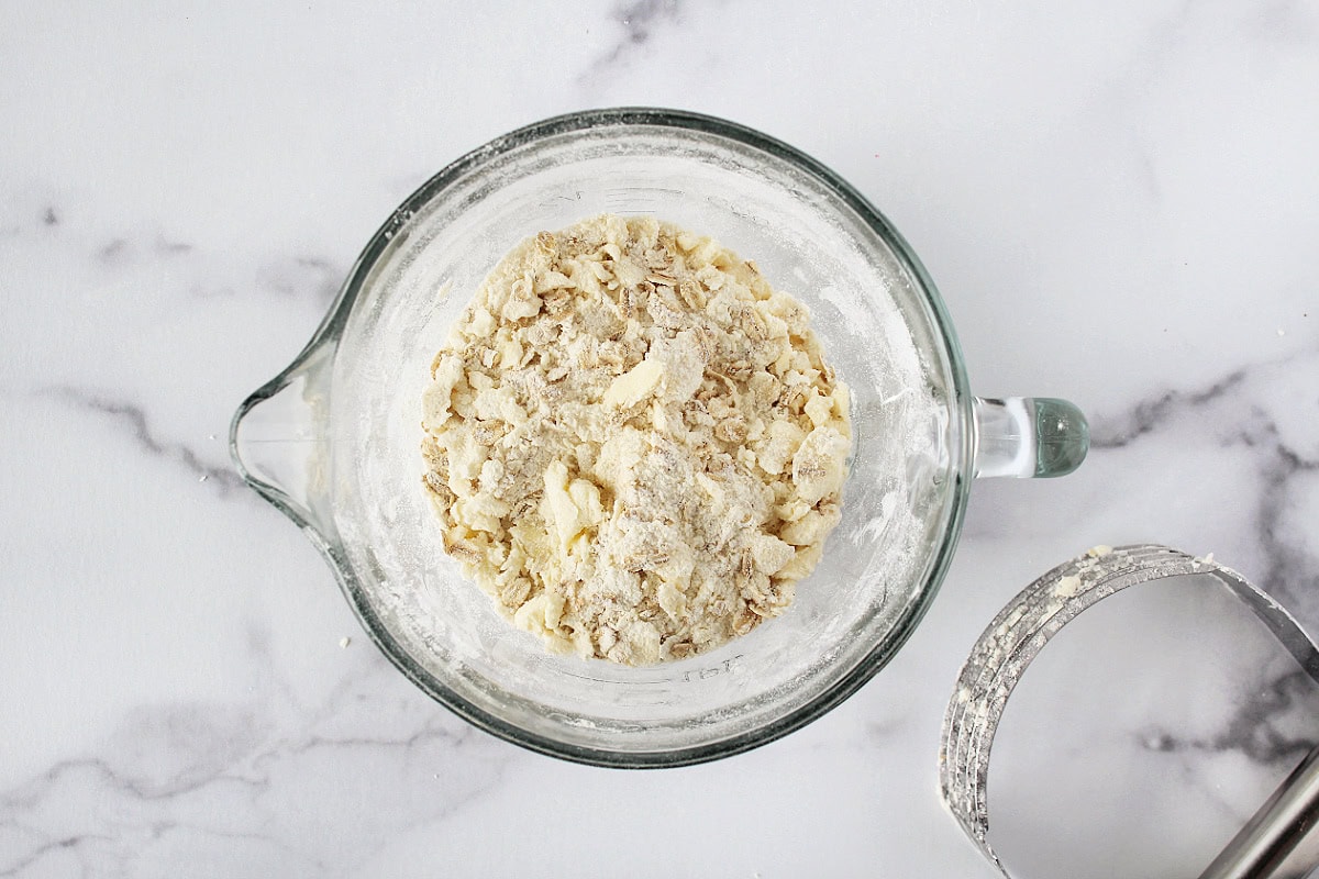 Crumble topping for coffee cake in a glass bowl with a pastry cutter beside it.