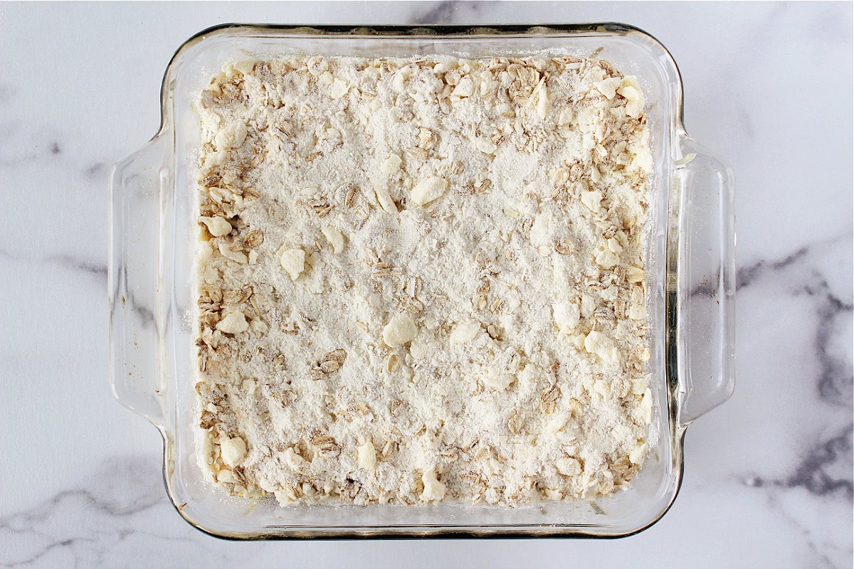 Crumble topping over cake batter in an 8x8 pan.
