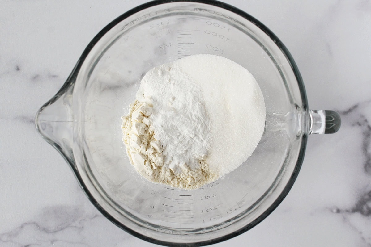 Flour, sugar, baking powder and salt in a glass mixing bowl.