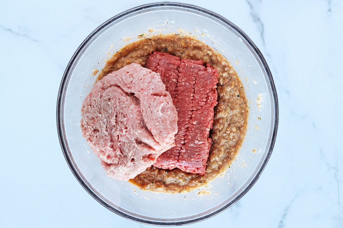 Ground beef and ground turkey on top of a cracker and seasoning mix.