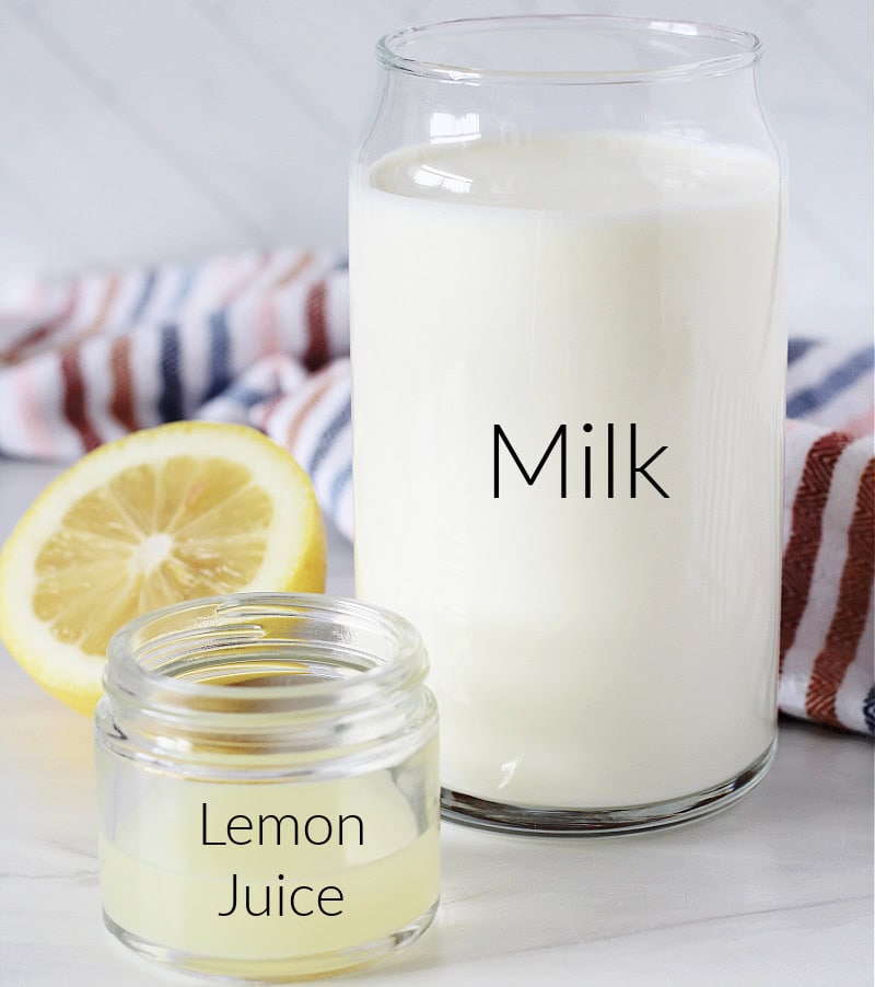 A labeled glass of milk and glass of lemon juice on a white countertop.