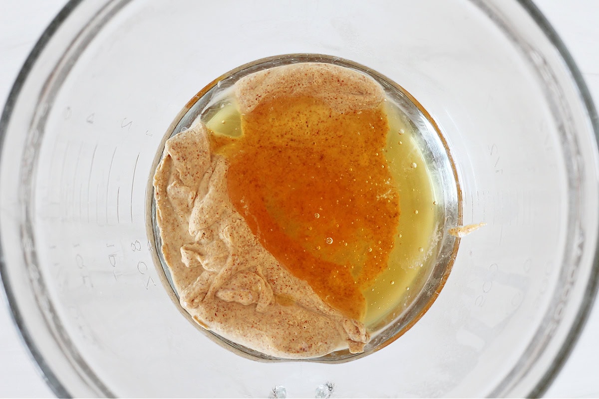 Honey, almond butter, and coconut oil in a glass bowl.