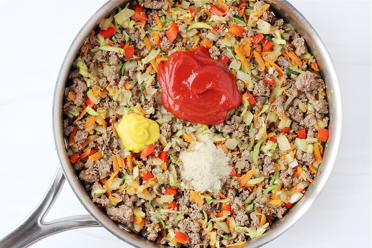 Browned ground meat, chopped veggie, ketchup, yellow mustard and garlic powder.