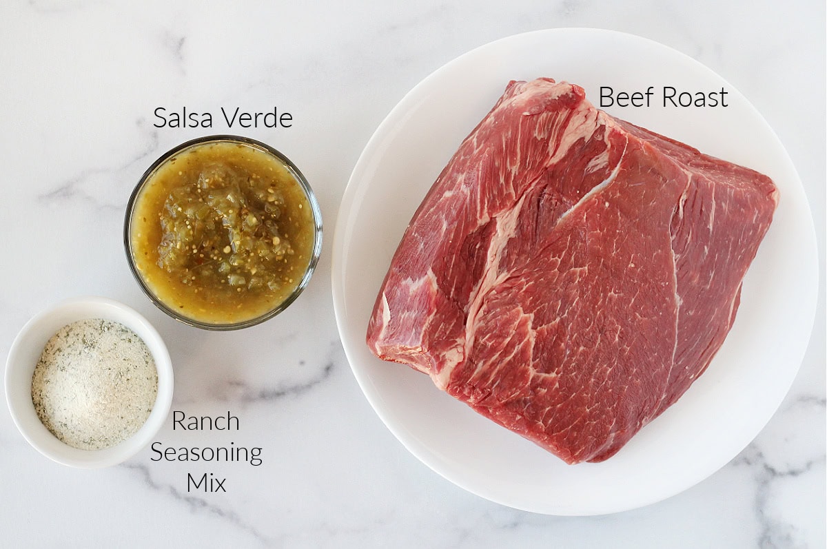 Three labeled ingredients for shredded beef verde on a white marble countertop.