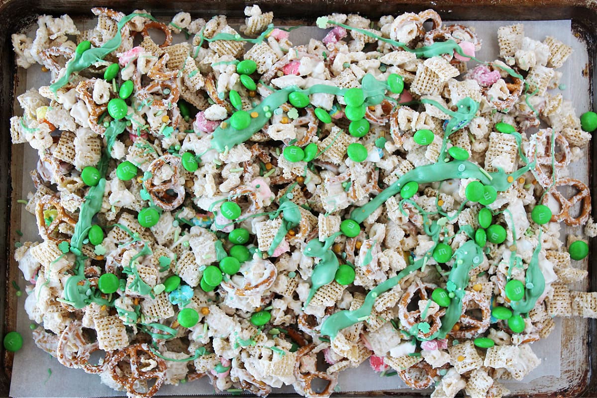 A baking sheet of leprechaun bait topped with green white chocolate drizzle.