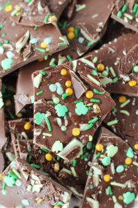 Close up view of chocolate leprechaun bark pieces topped with St. Patrick's Day sprinkles.